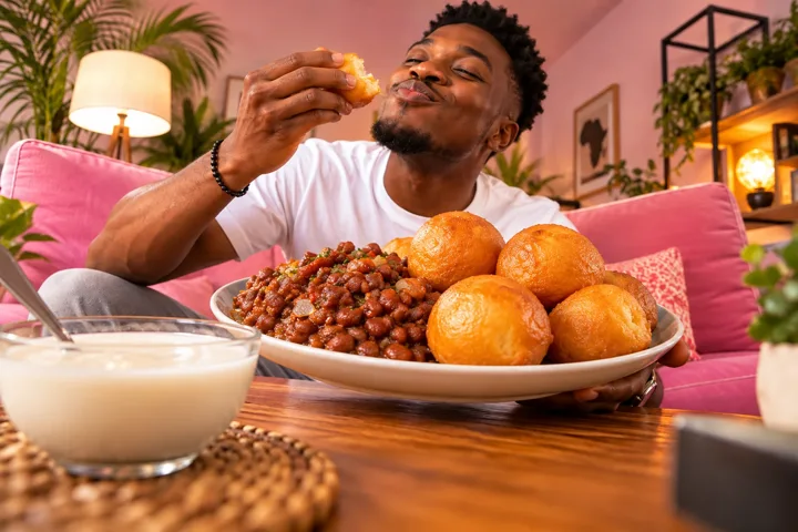 Un homme savoure des beignets avec des haricots et de la bouillie