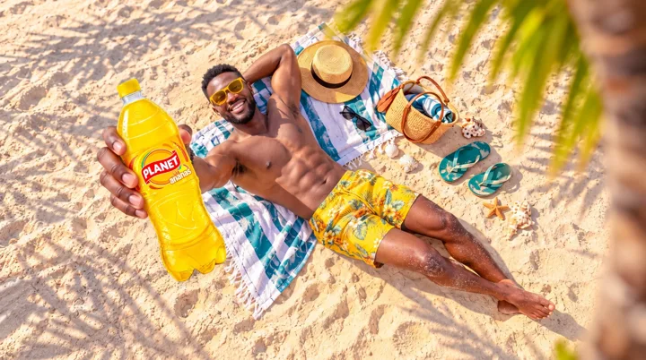 Un couple en tenue estivale avec une bouteille Planet sur une plage